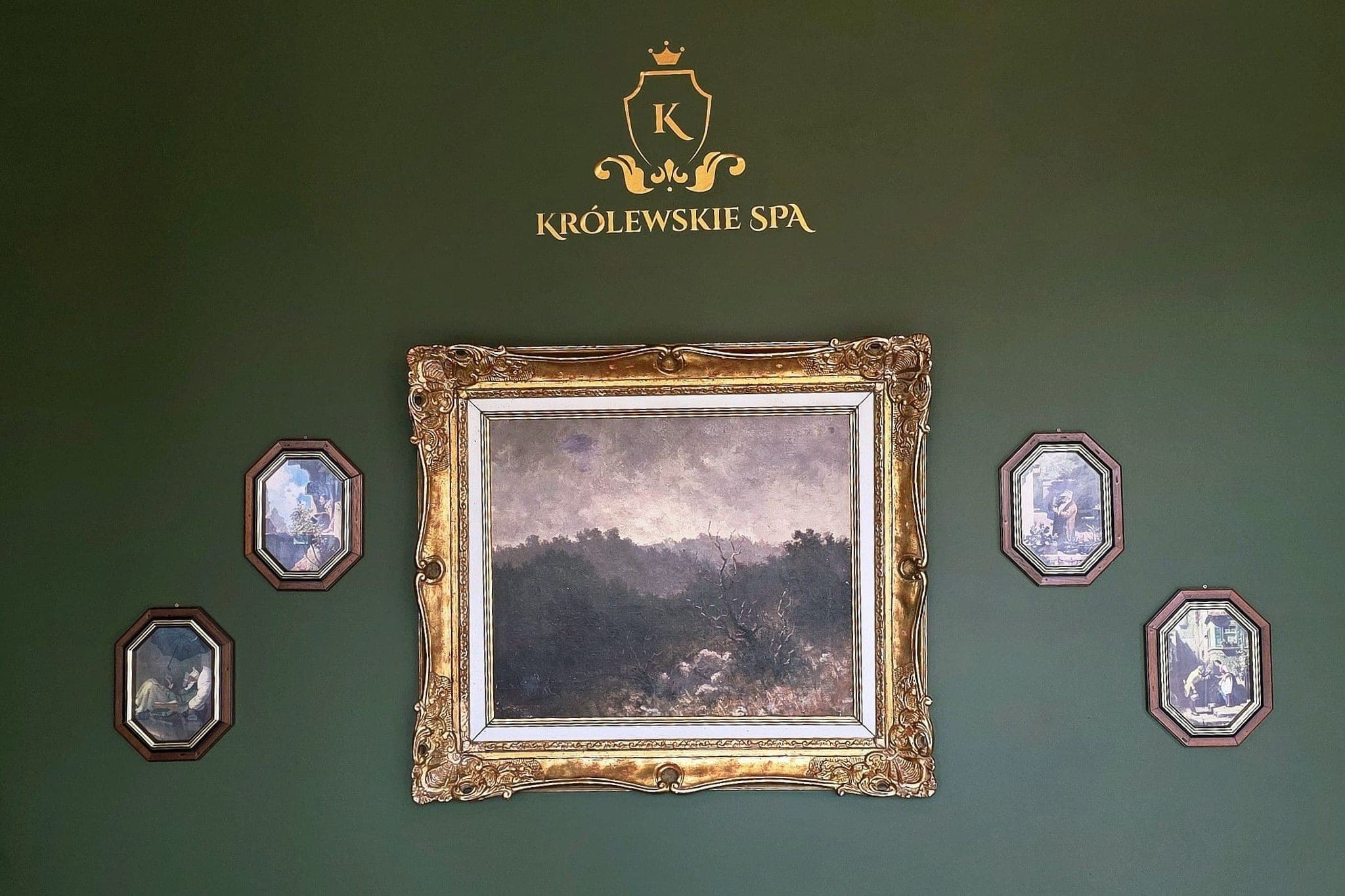 Salon - elegancka ściana z obrazami i logo Królewskiego SPA
